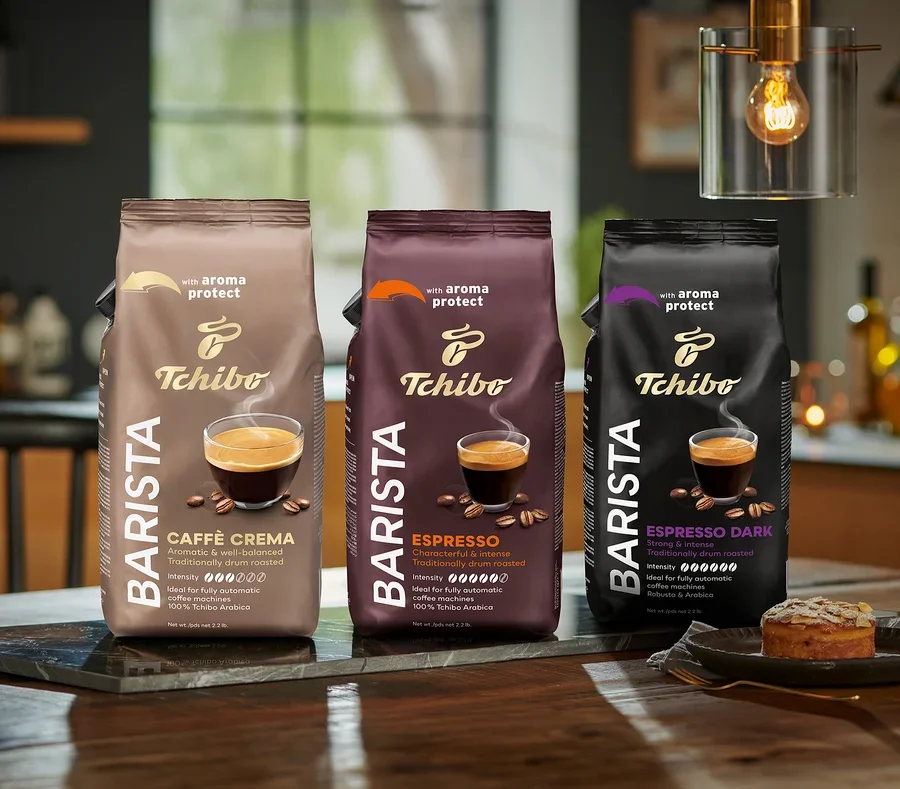 Három csomag Tchibo Barista kávébab áll az asztalon, balról jobbra: Caffè Crema, Espresso és Espresso Dark.