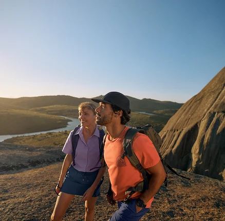 Két túrázó outdoor hátizsákokkal és ruházattal sziklás terepen.
