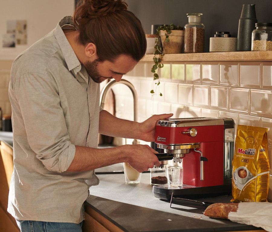 Férfi kávét készít egy piros »Lapressa« karos eszpresszó kávéfőzővel.