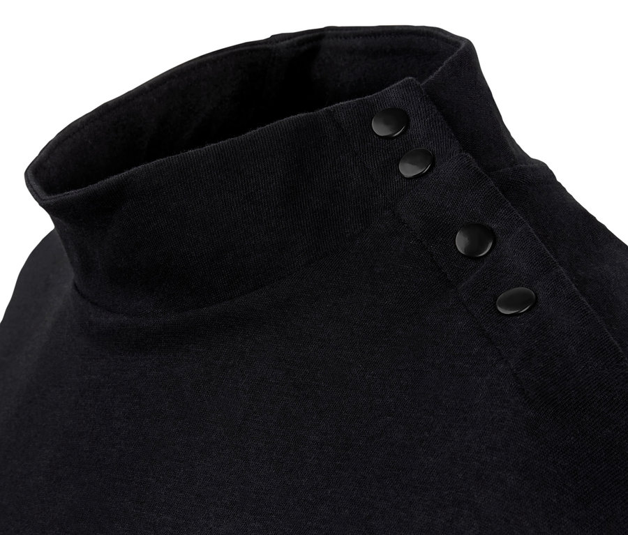 Egy fekete, denevérujjú, gombos felső részletfotója.