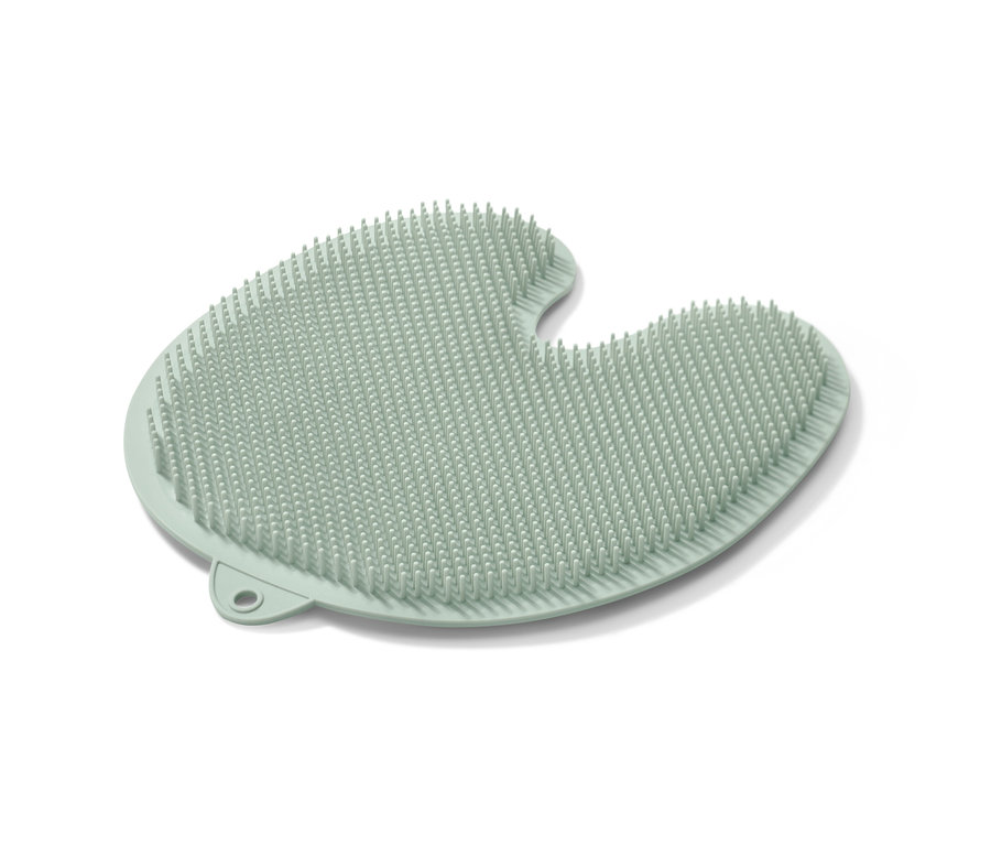 Egy világoszöld szilikon lábtisztító alátét tapadókoronggal a fehér háttér előtt.