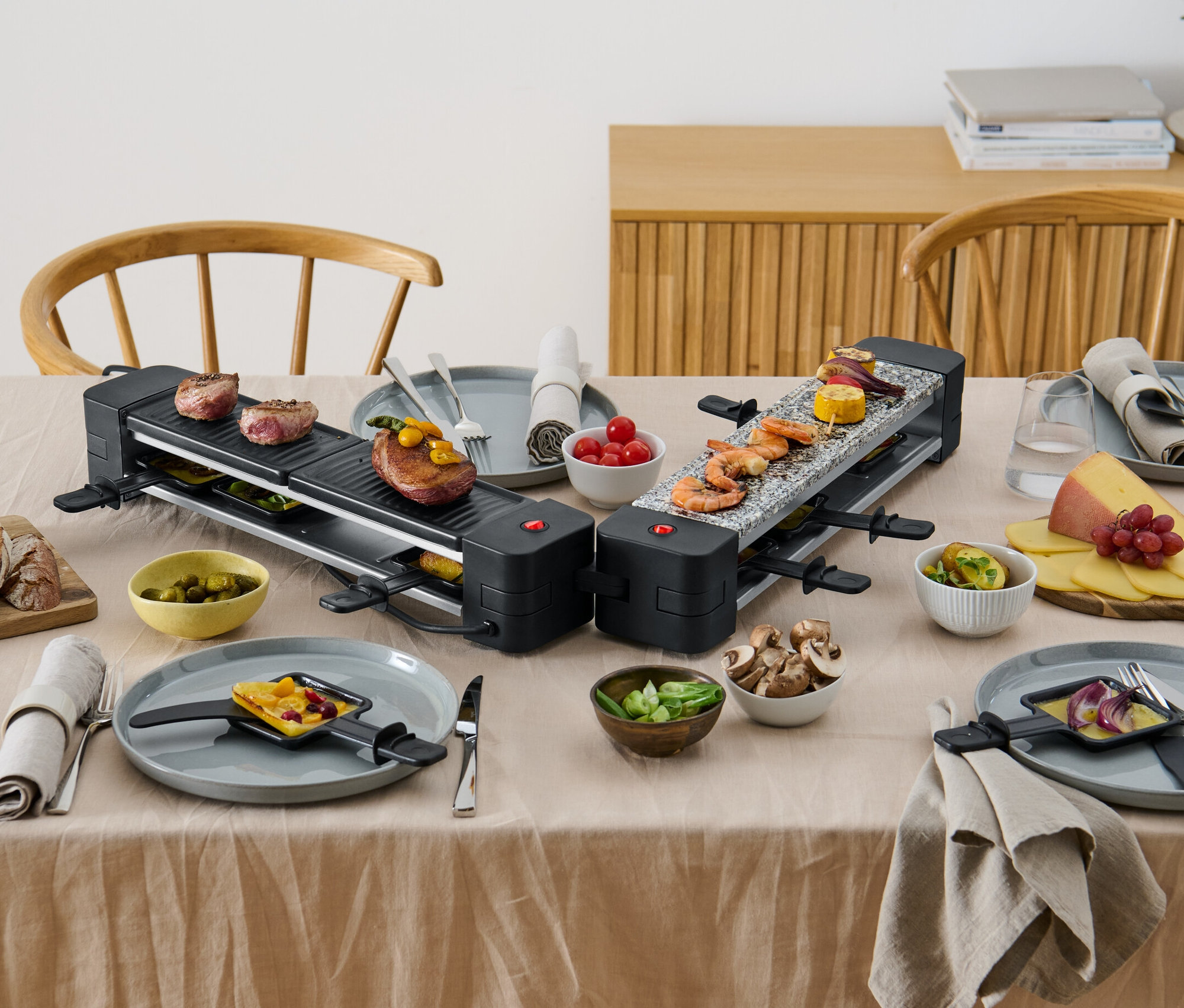 Két összecsukható raclette grillsütő étellel az asztalon.