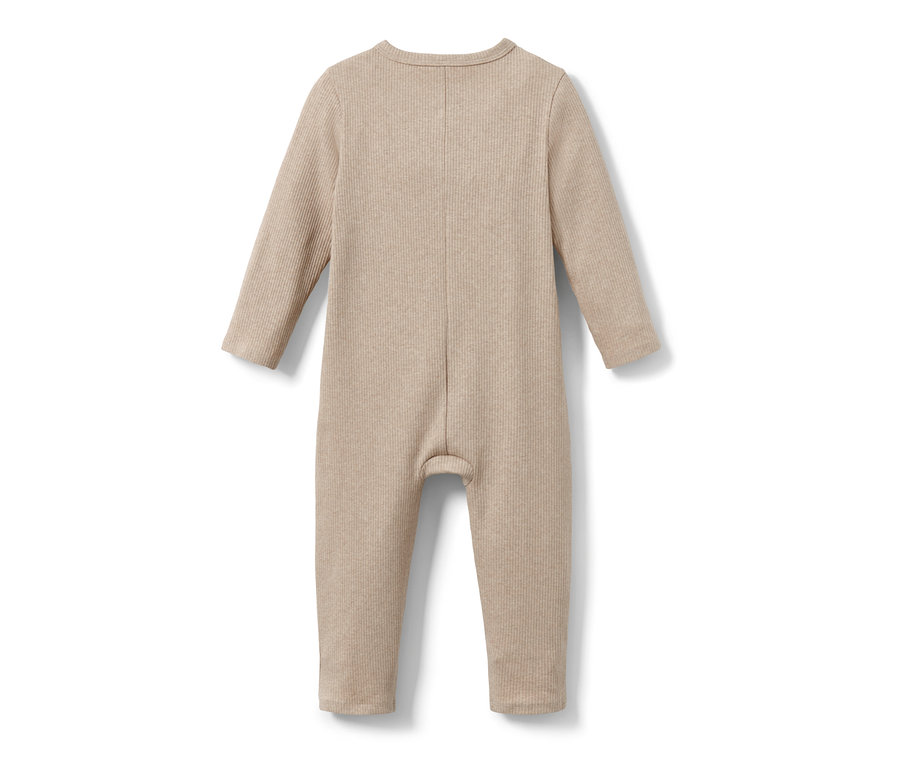 A bézs színű kisgyerek kezeslábas részlete.