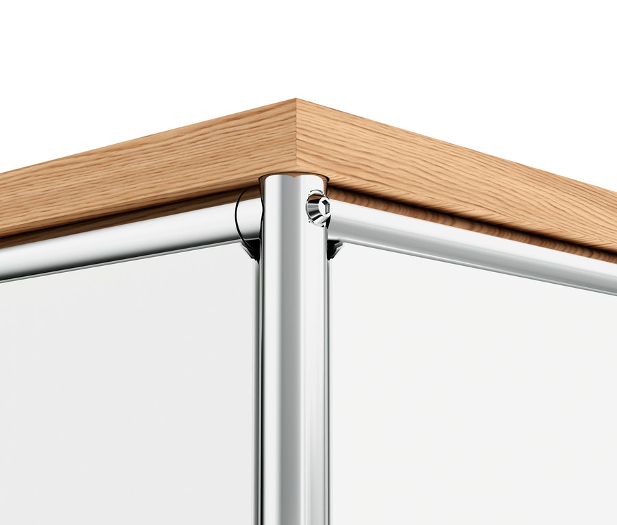 Egy fehér, fa felső lapú, 1 lenyíló ajtóval és 4 fiókkal rendelkező »CN3« fém komód sarkának részlete.