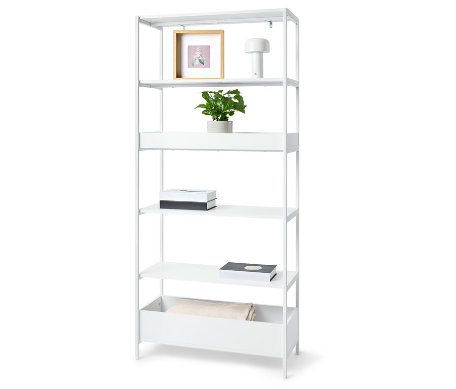 Fehér könyvespolc öt polccal, növényekkel, képkerettel, lámpával, két dobozzal és egy takaróval.