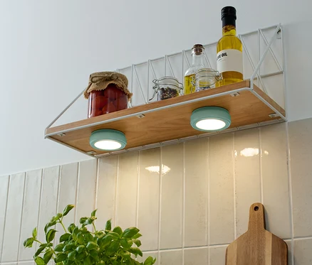 A polcon tárolóedények és olajos üvegek találhatók, alattuk két türkizkék 2 LED-Multifunktionsleuchten.