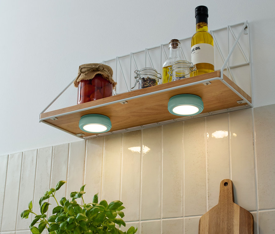 A polcon tárolóedények és olajos üvegek találhatók, alattuk két türkizkék 2 LED-Multifunktionsleuchten.
