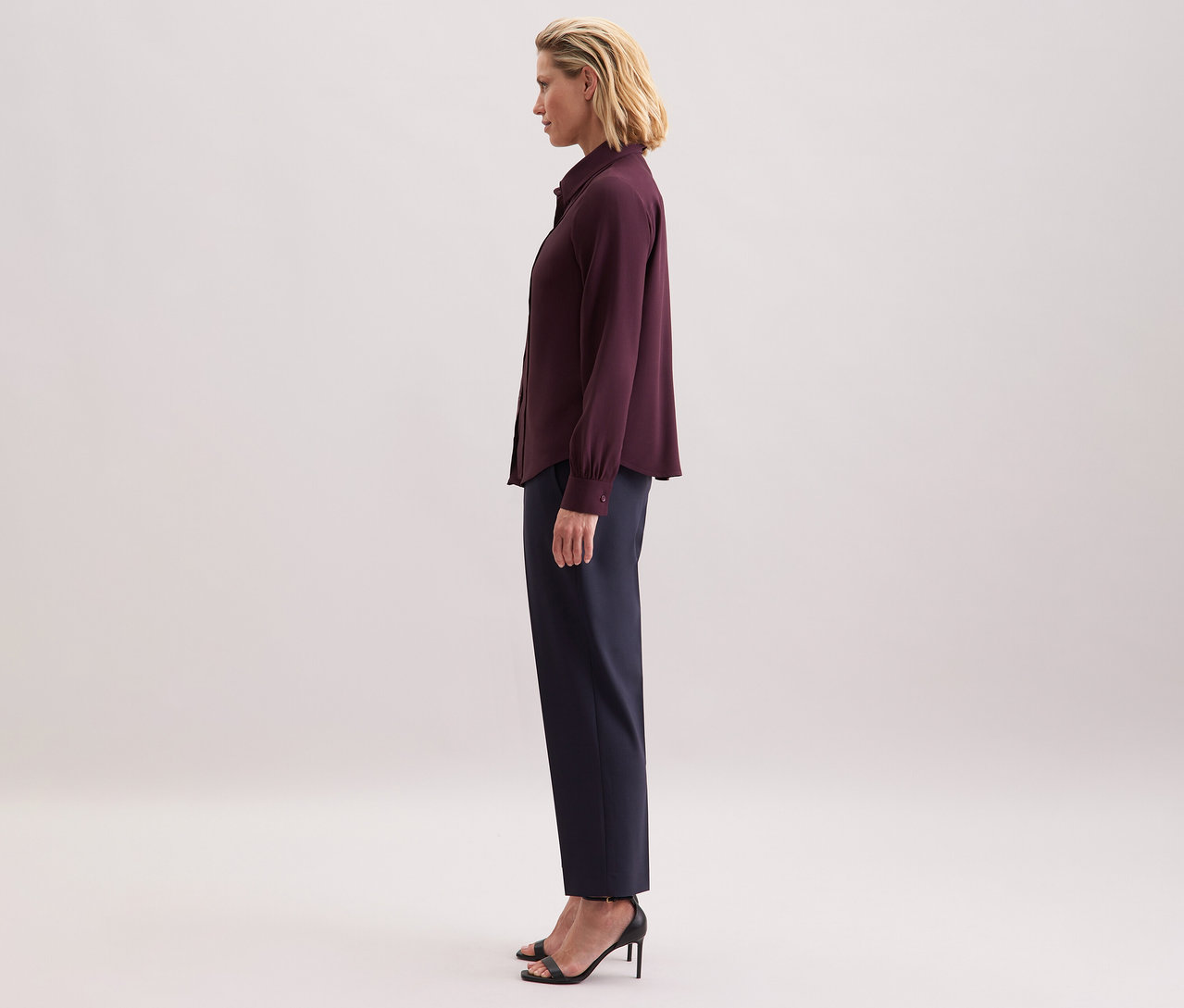 Nő visel Seidensticker sifon blúzt viszkózból, sötét nadrágot és fekete szandált.