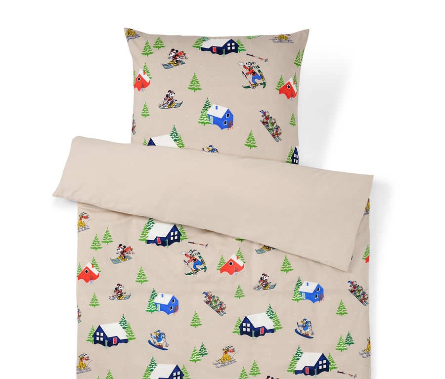 Ágyneműhuzat téli tájmintával, házakkal, fákkal és síelőkkel.