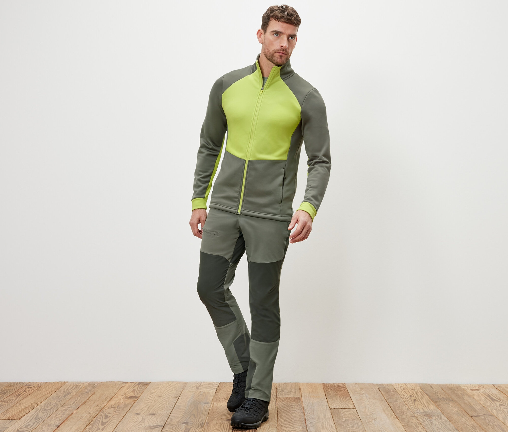 Férfi pózol khaki/lime termofelsőben és nadrágban.