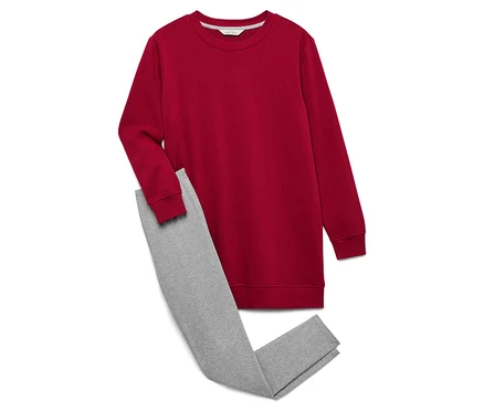 Egy piros pulóver és egy szürke leggings fekszik egy fehér háttéren.