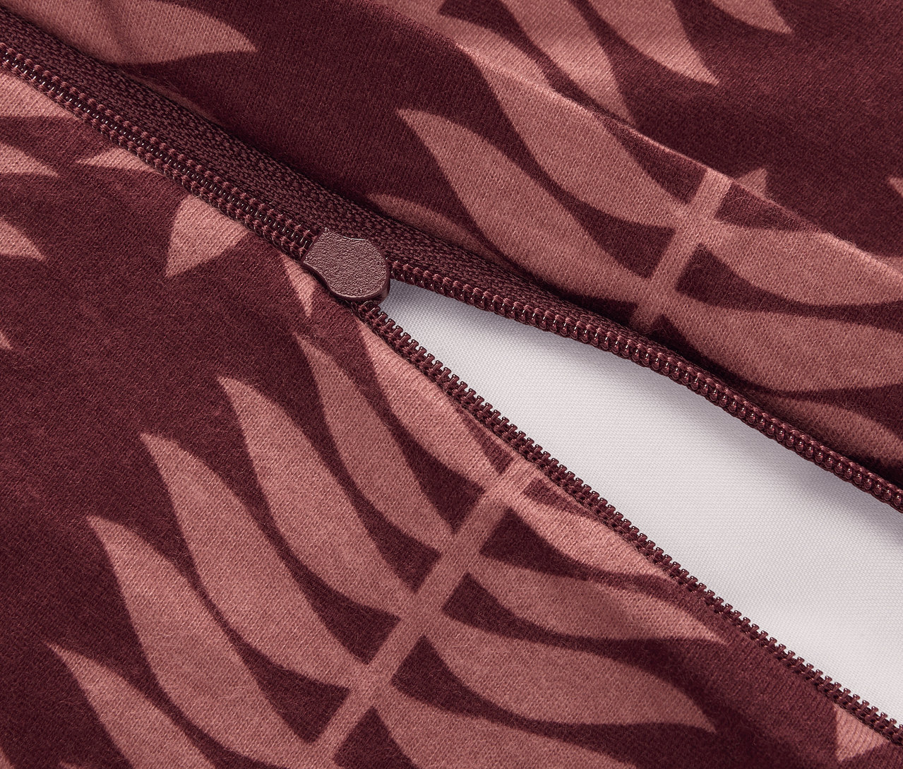 Közelkép egy cipzárról egy normál méretű, leveles mintázatú, téli jersey ágyneműn.