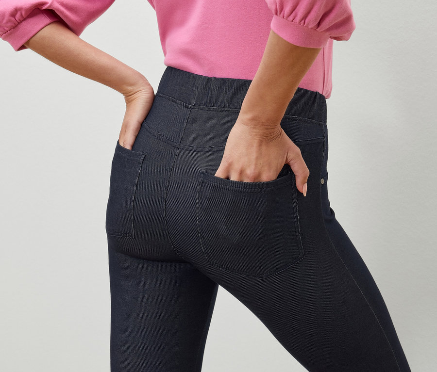 Nő keze sötétkék jeggings nadrág zsebében.