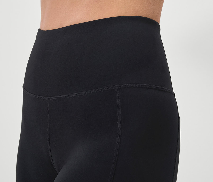 Egy személyen látható fekete leggings közelképe.