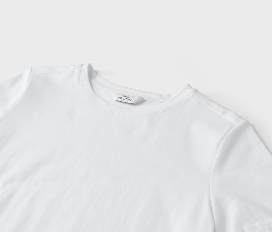 Egy fehér póló közeli képe "Tchibo My Style" feliratú címkével.