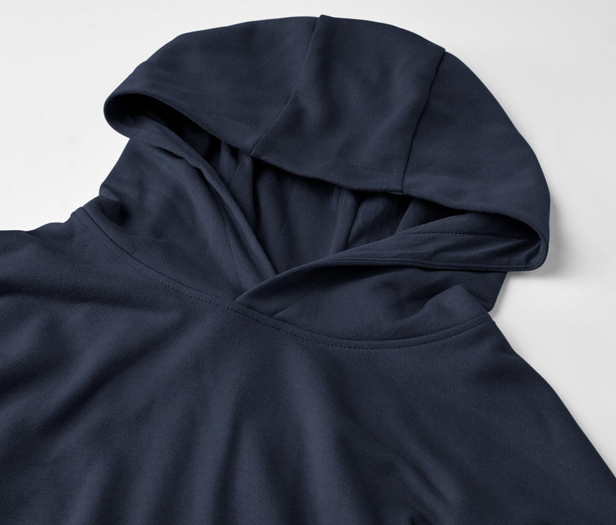 Egy sötétkék kapucnis pulóver közeli képe fehér háttérrel.