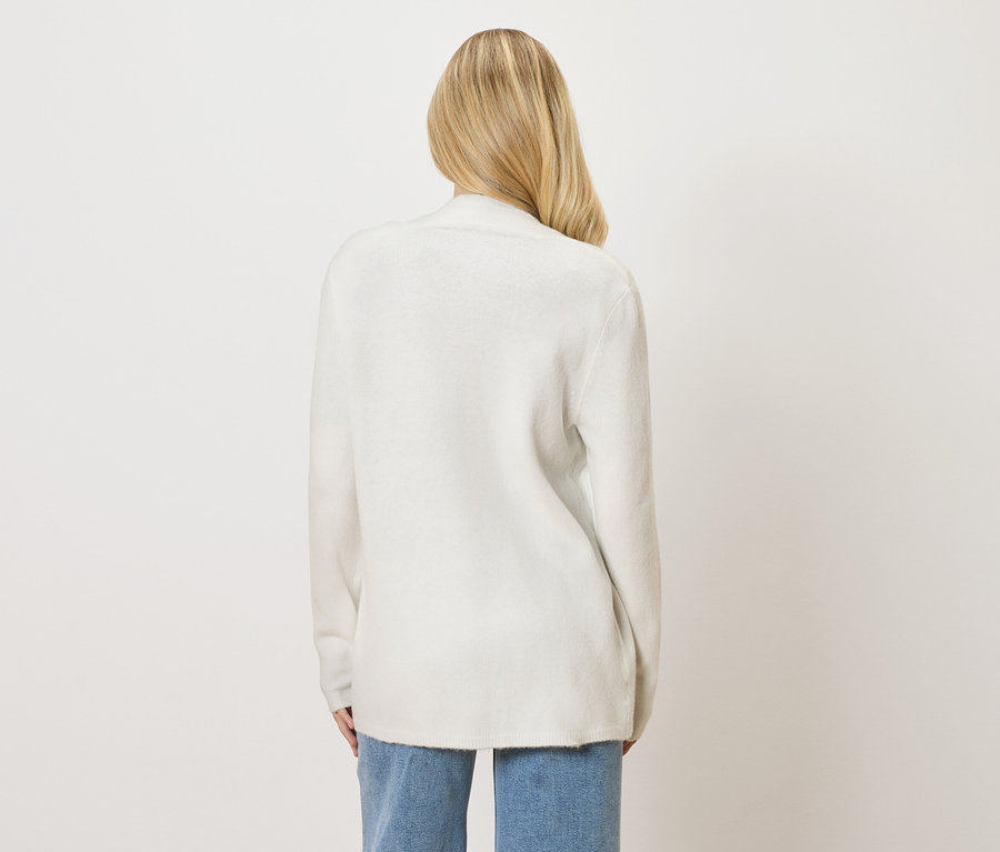 Hátulnézet egy szőke hajú nőről, aki fehér kardigánt és farmert visel.