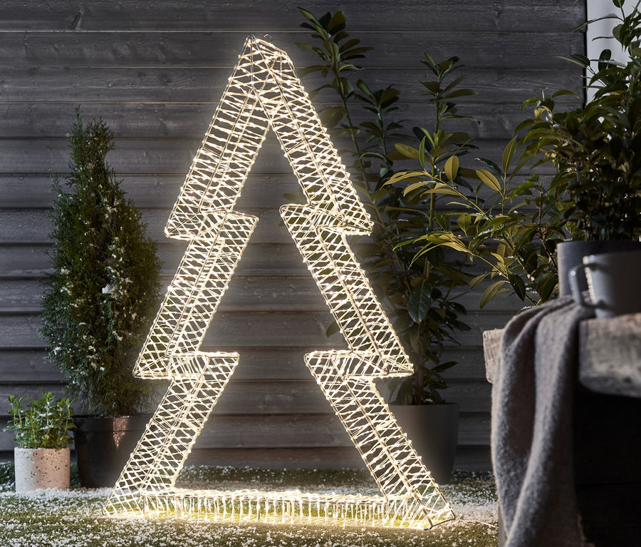 Egy közepes méretű, világító 3D LED-fenyő áll kint a gyepen.
