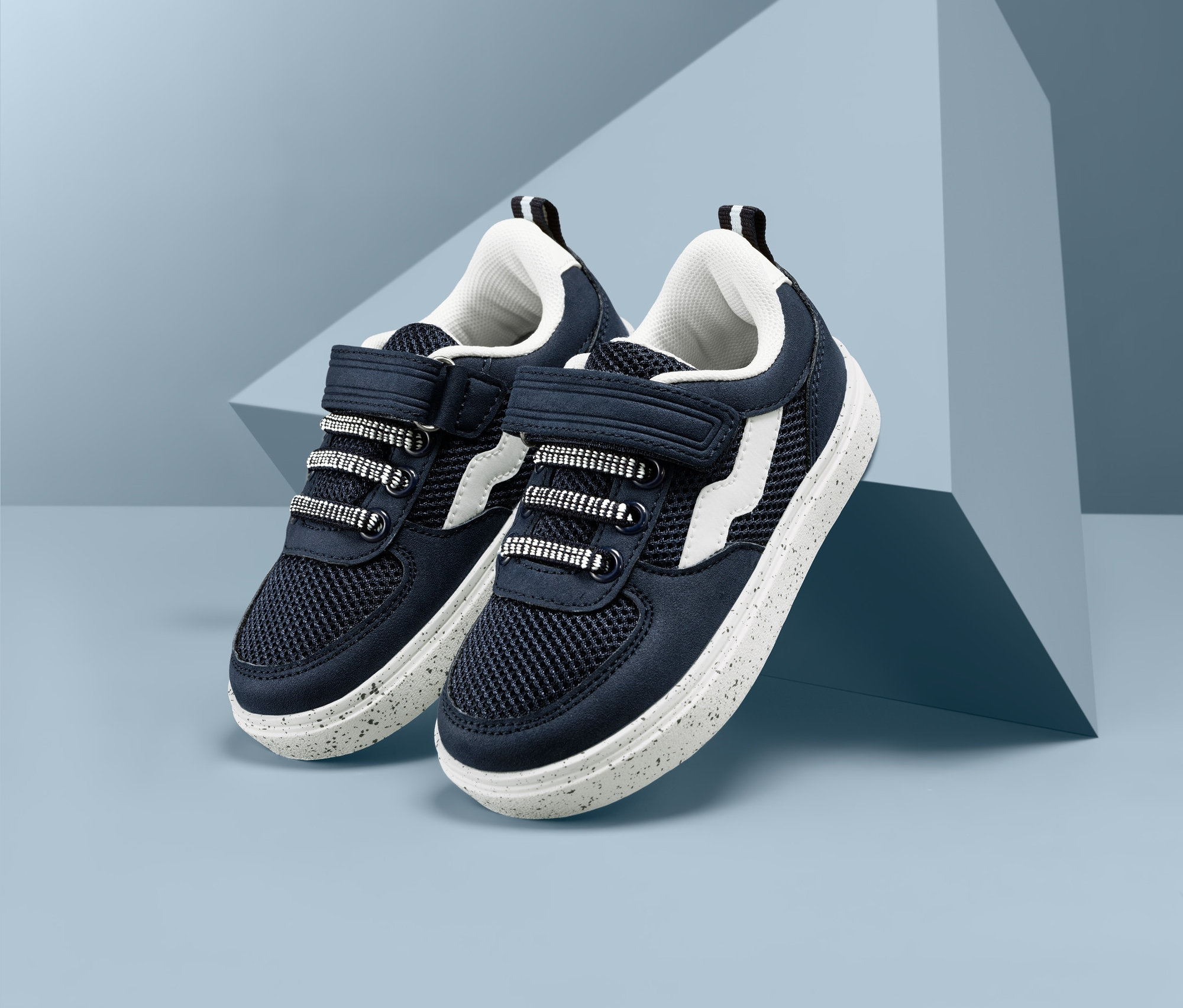 Két sneaker cipő világoskék háttéren.