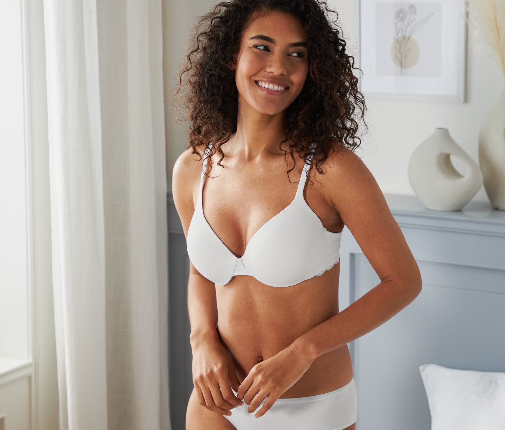 Nő visel egy fehér kosaras melltartót.