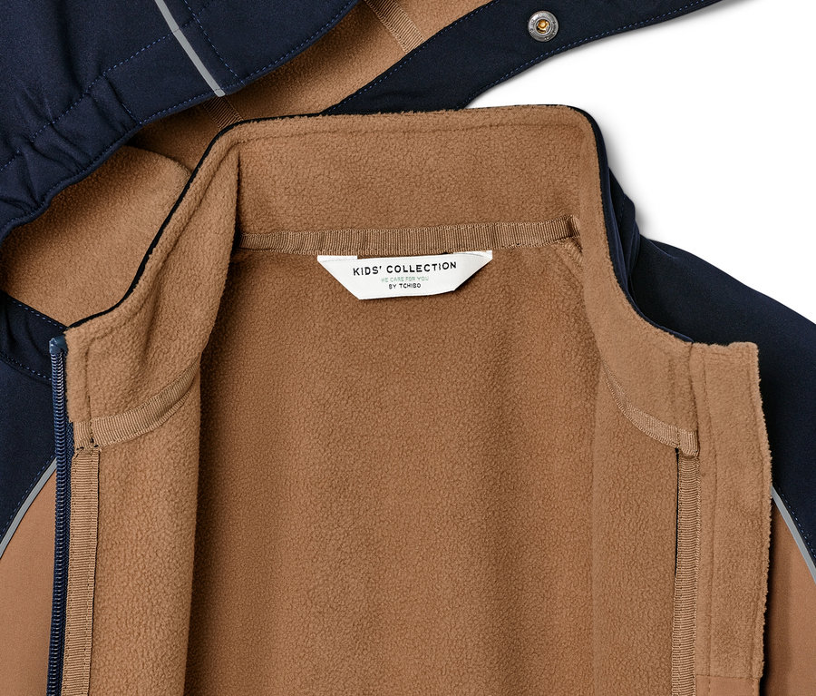 Részlet egy barna fleece bélésű gyerek softshell dzsekiről.