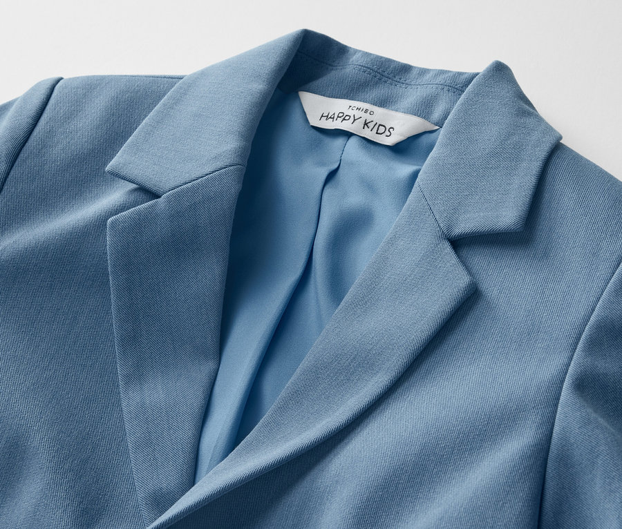 Egy kék kisfiú zakó részlete.