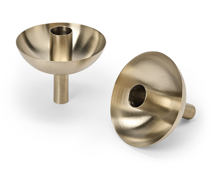 Két arany gyertyatartó fehér háttérrel.