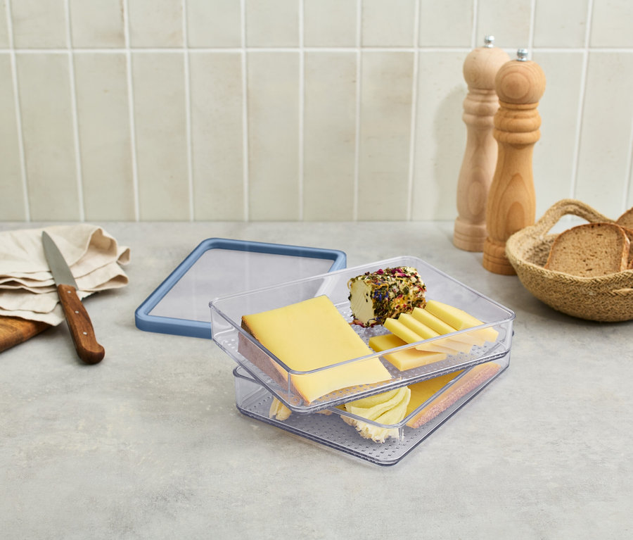 Doboz felvágottak számára sajtokkal és felvágottakkal egy asztalon.