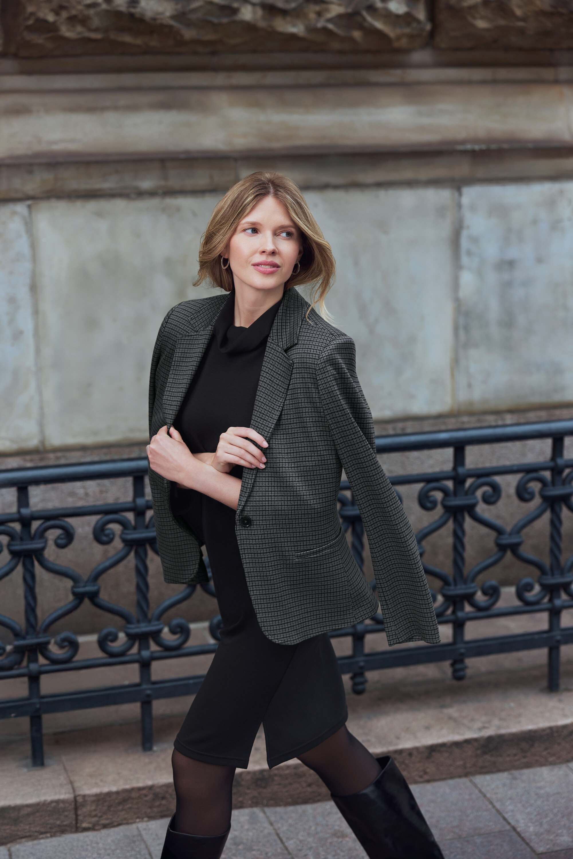 Egy nő sétál kint, blézert és Női fülbevaló, Wave fülbevalót visel.