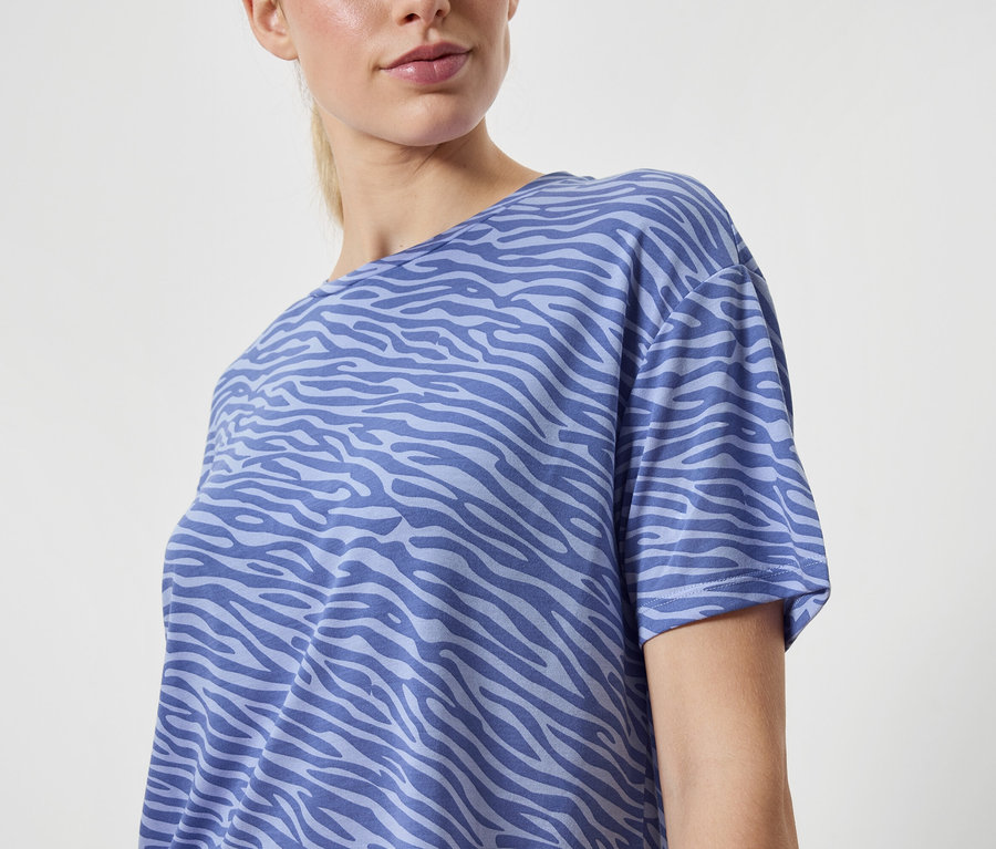 Nő visel kék, állatmintás pólót.