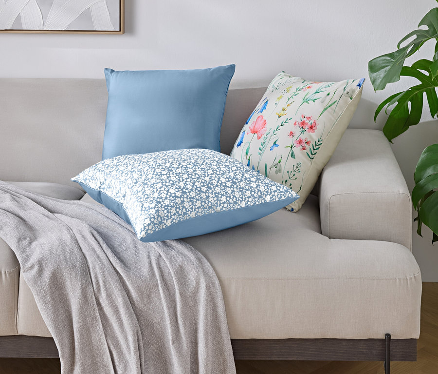 A kanapén három párna és egy takaró van.