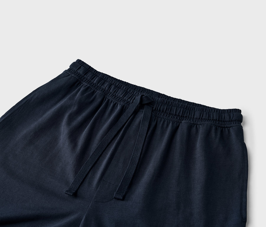 A tengerészkék színű melegítő alsó részlete, húzózsinórral a derékrészen.