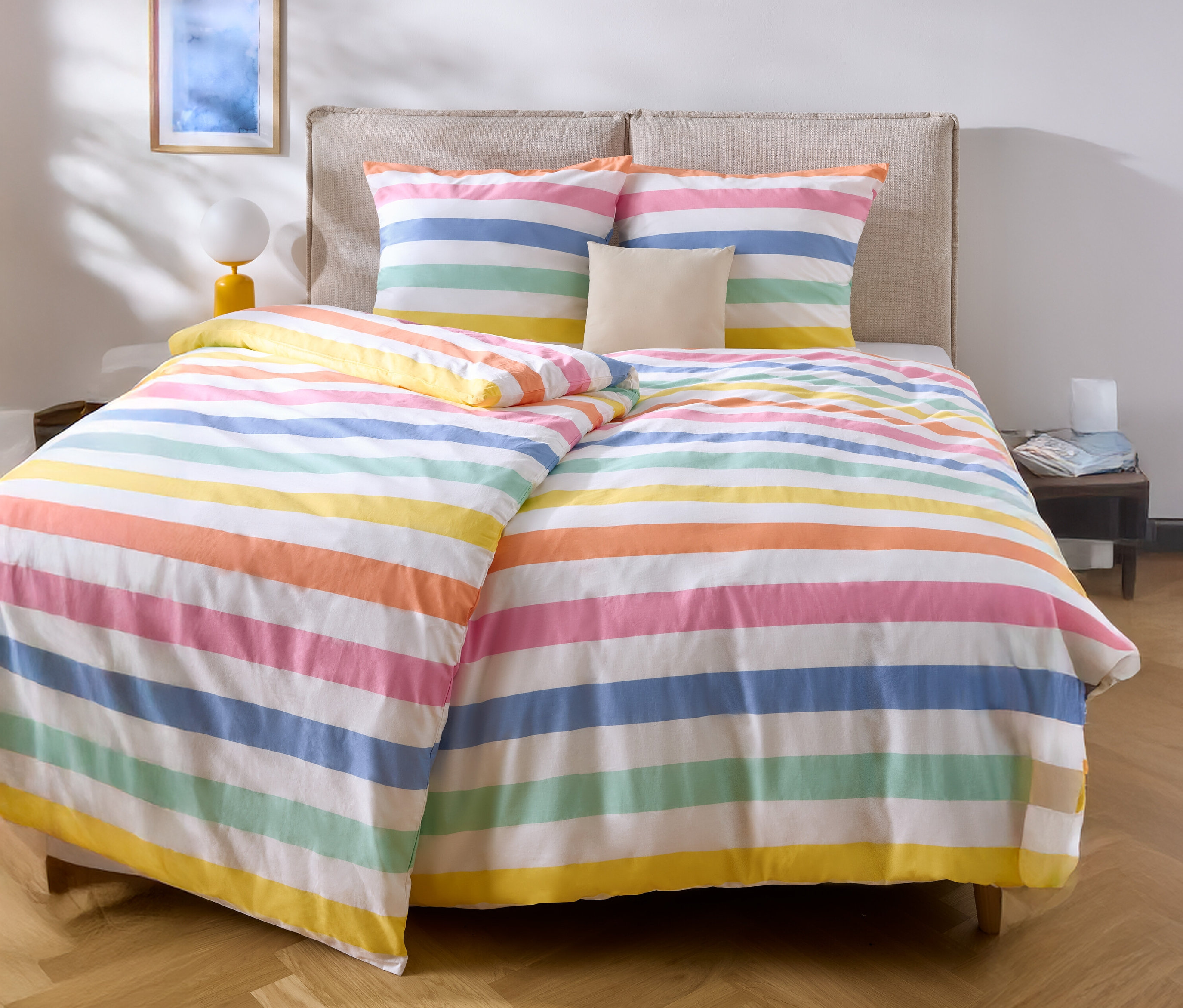 Ágy színes, csíkos ágyneművel és két párnával.