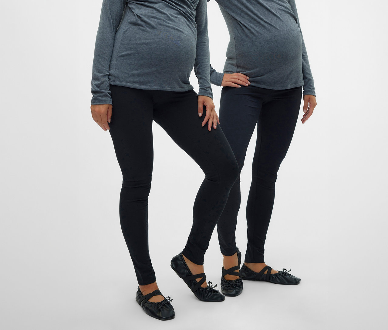 Két terhes nő szürke felsőt és fekete 2 db MAMALICIOUS kismama leggingst visel balerinacipővel, fehér háttér előtt.