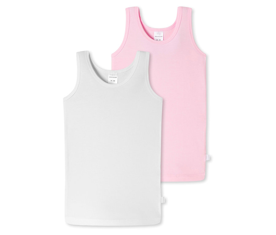 Egy fehér SCHIESSER gyerektrikó fekszik az előtérben, mögötte egy rózsaszín.