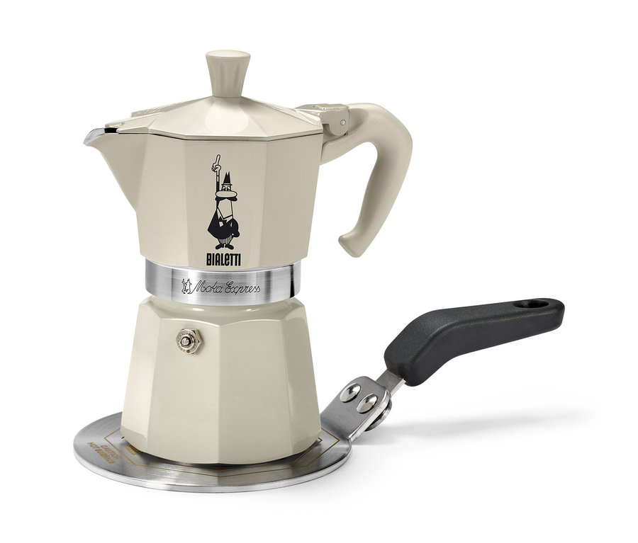 Egy bézs Bialetti kotyogós kávéfőző áll egy 13 cm-es Bialetti indukciós átalakítólapon.