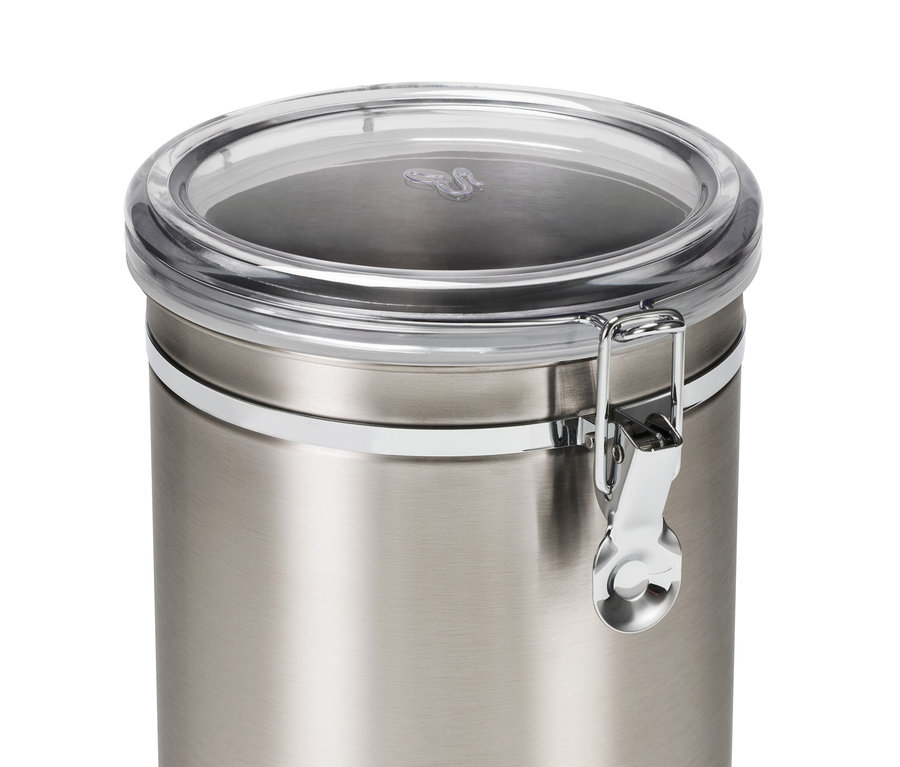 Egy 1 kg-os, rozsdamentes acélból készült aromatároló doboz közeli képe, átlátszó fedővel és zárral.