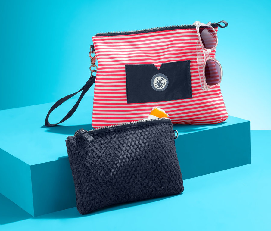 Két táska türkiz háttér előtt. Az egyik táska piros-fehér csíkos, napszemüveggel. A másik táska sötétkék. 2 női táska, sötétkék, piros, csíkos