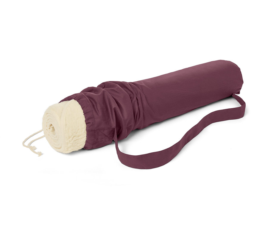 Egy feltekert nyírt gyapjú jógamatrac bordó színű hordtáskában, pánttal.