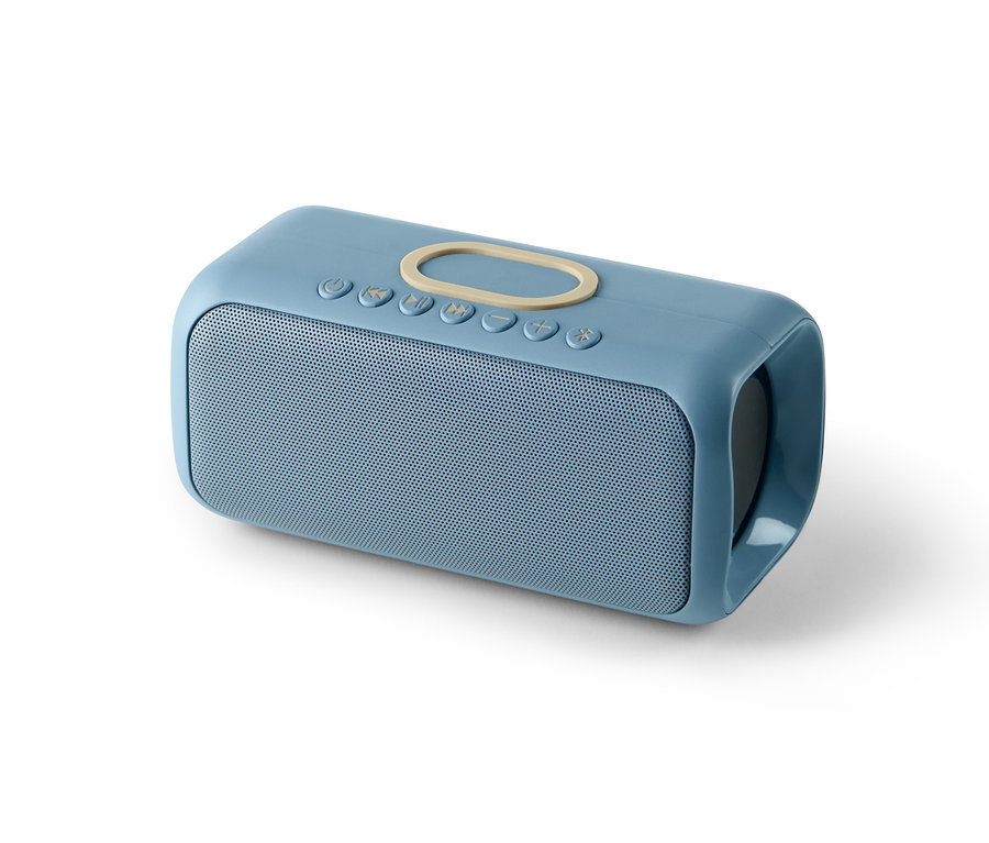 Kék Bluetooth hangszóró vezeték nélküli töltővel, fehér háttérrel.