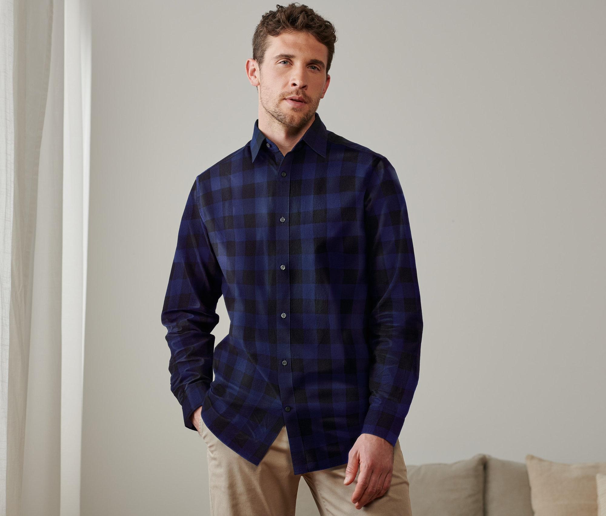 Férfi pózol sötétkék/kék kockás flanelingben.