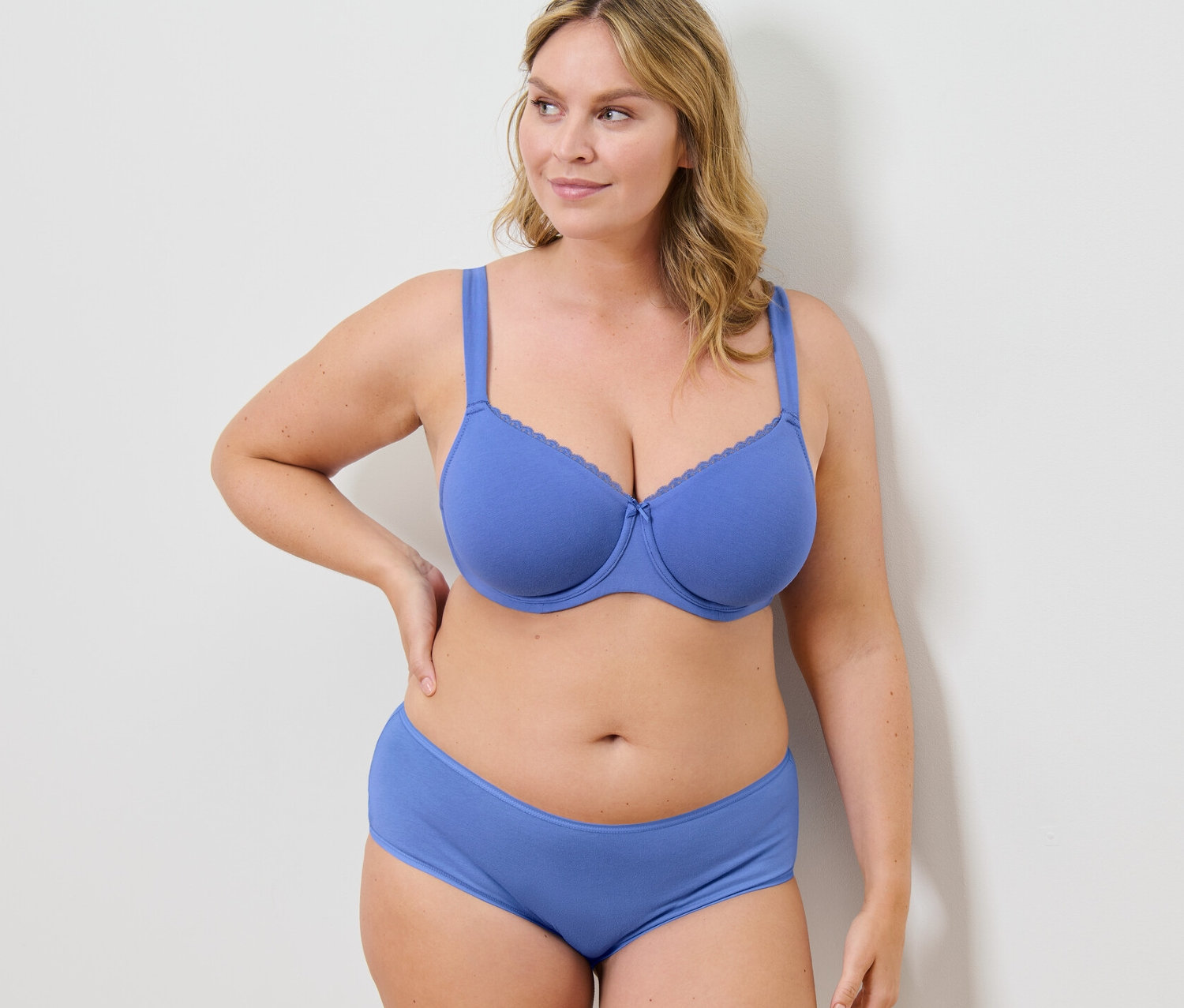 Nő kék merevítős melltartót és alsót visel.