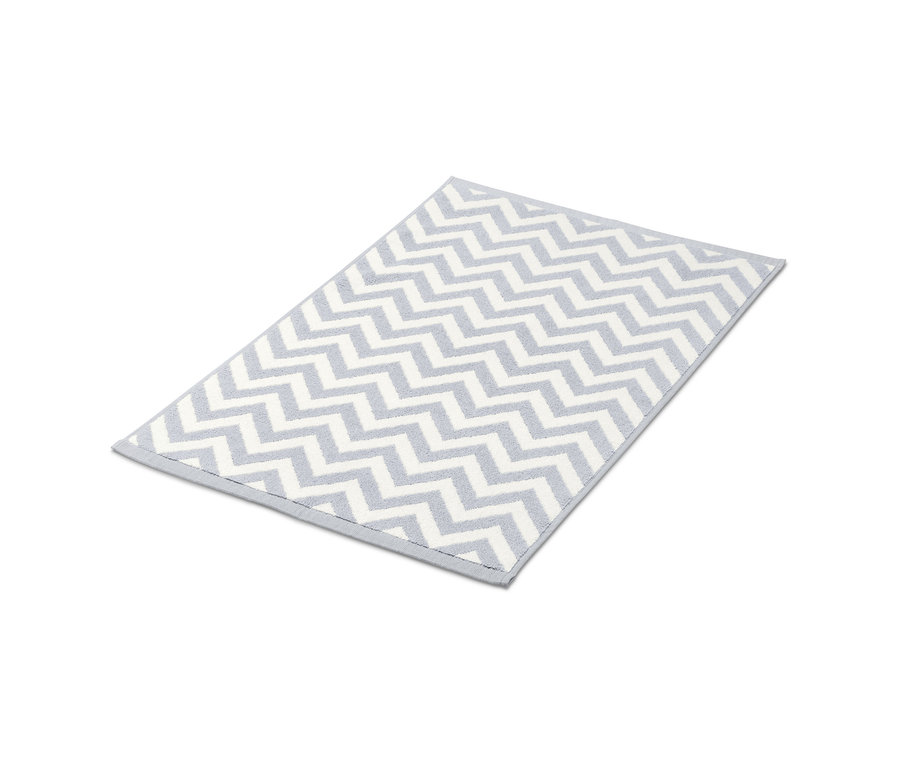 Szürke-fehér fürdőszobaszőnyeg cikcakk mintával.