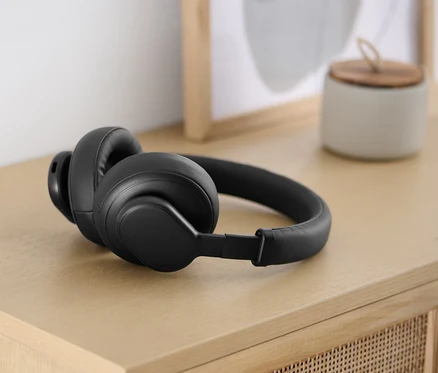 Fekete Bluetooth® fejhallgató érintőfunkcióval világos fa asztalon.