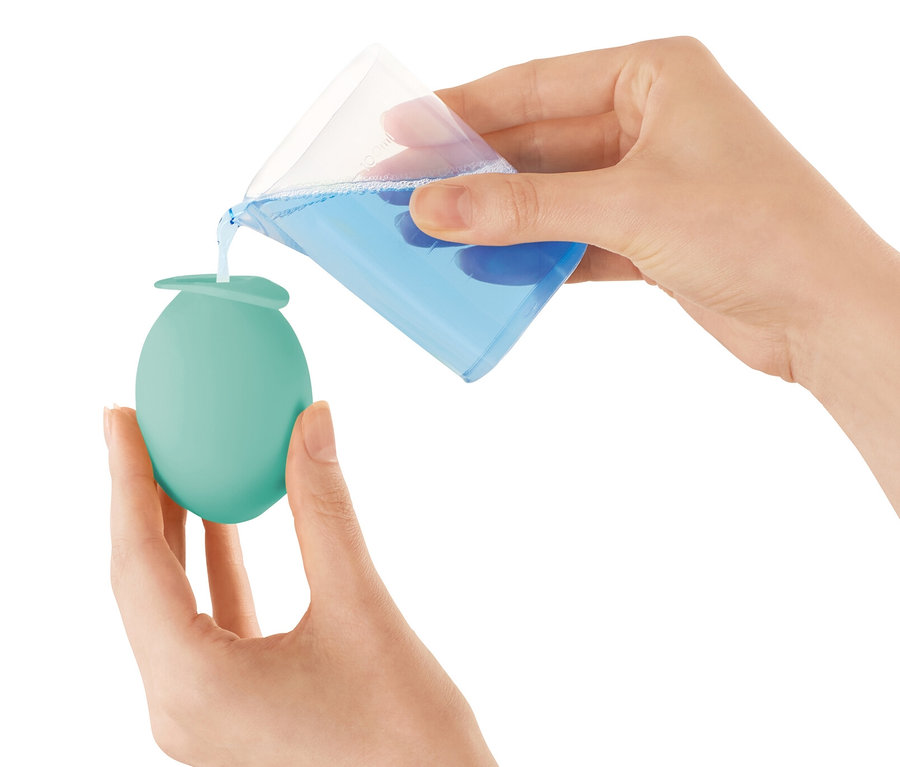 Nő folyadékot önt a vízkőmentesítő fej vízcsapra termékbe.