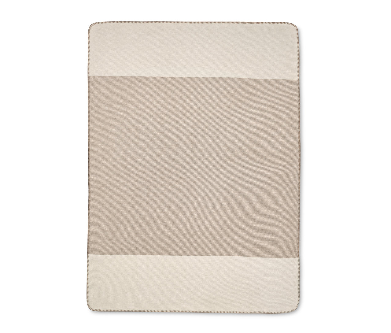 Egy bézs-krémszínű takaró.