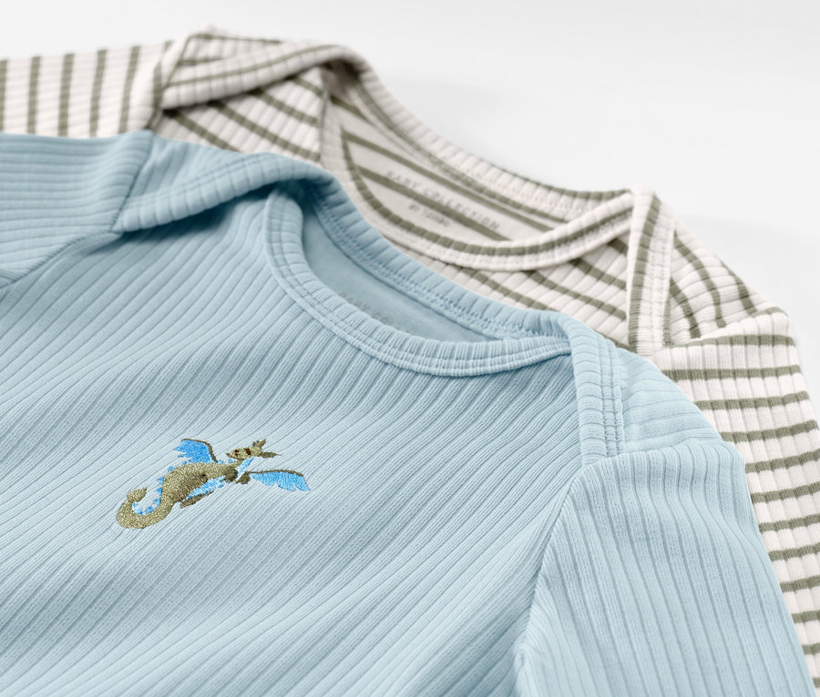 Két hosszú ujjú, bordás babaruha, világoskék hímzéssel és zöld-fehér csíkos.