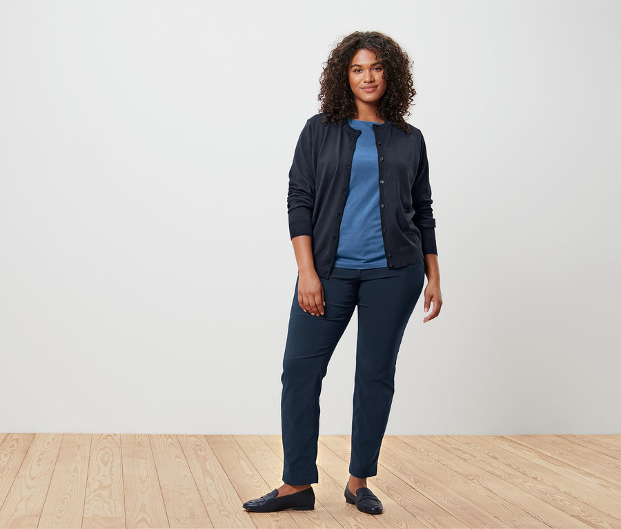 Nő kék, félhosszú ujjú felsőt és kardigánt visel.