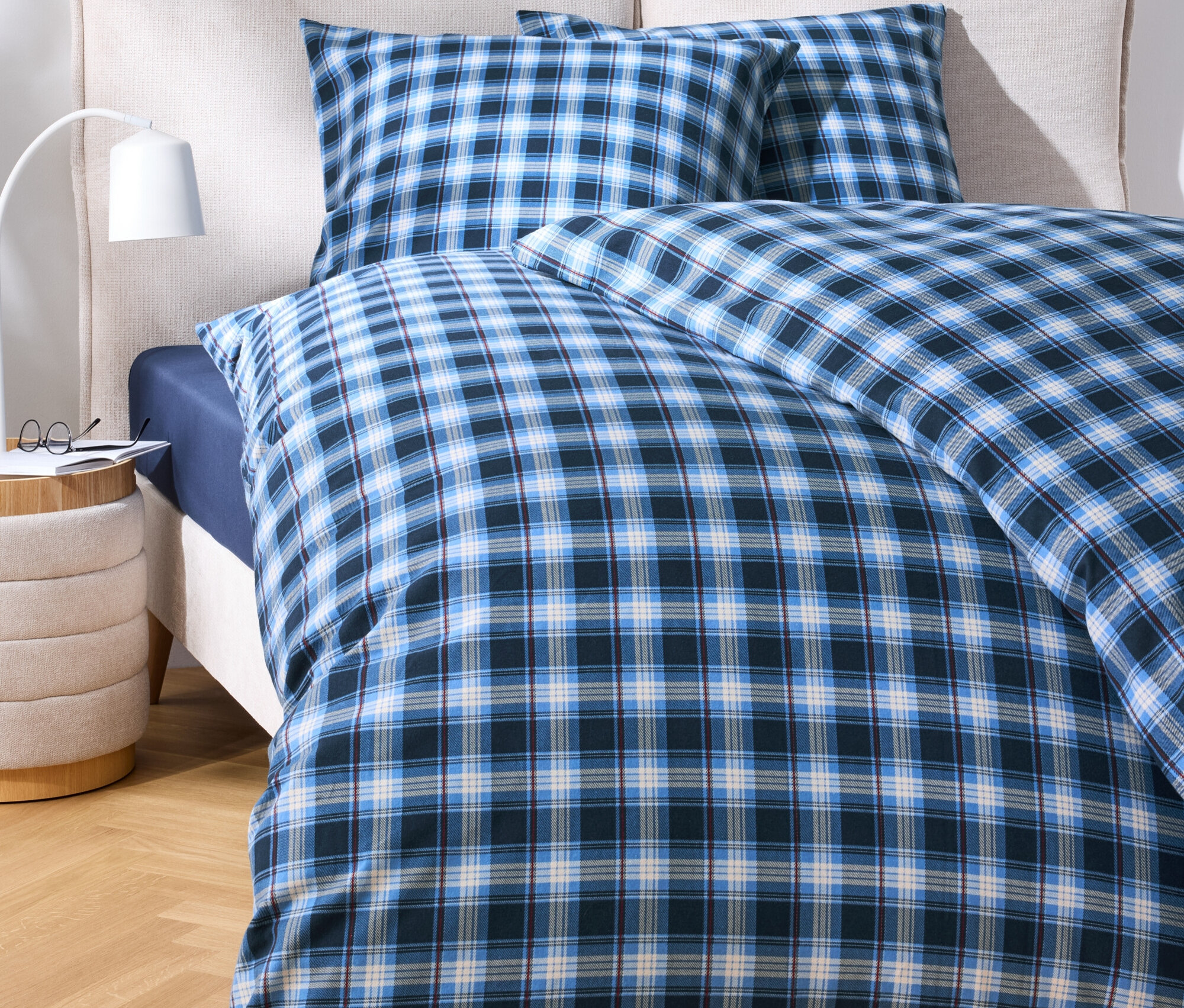 Ágynemű kék kockás mintával egy ágyon.