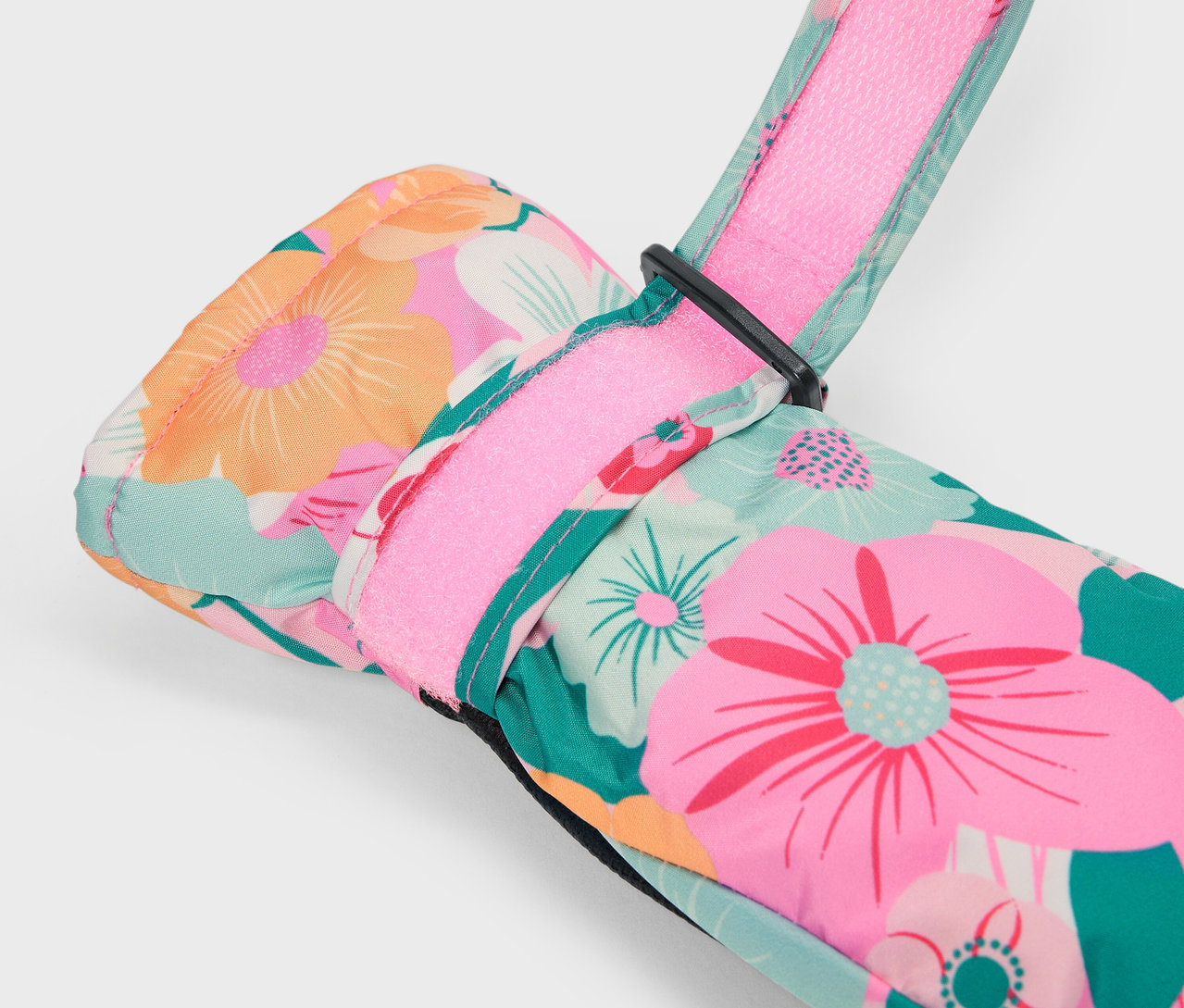 Egy színes, virágmintás síkesztyű részlete rózsaszín pánttal.